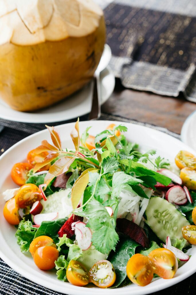 Healthy fresh salad with cucumbers, tomatoes, and tropical coconut in Bali.